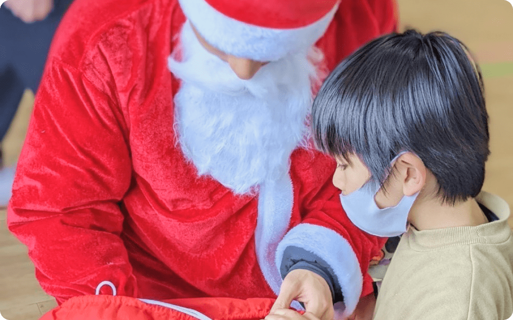 画像：クリスマスツリーの飾りつけをする子供